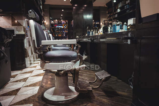 Cadeiras de barbeiro organizadas em uma fileira na barbearia — Fotografia de Stock