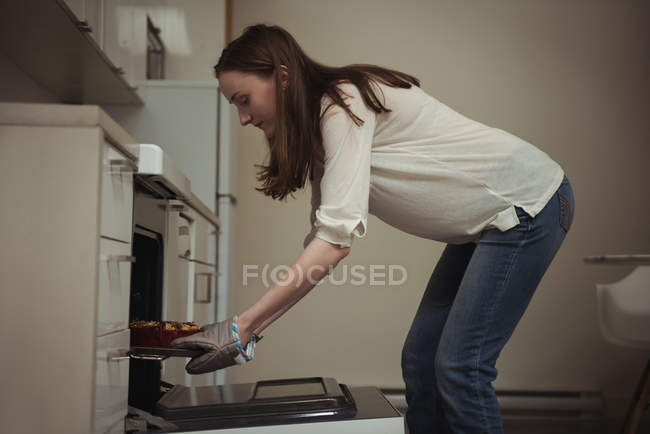 Жінка видалення запечений пиріг з духовки кухні в домашніх умовах — стокове фото