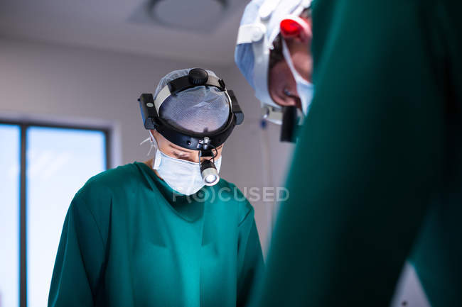 Surgeons wearing surgical loupes while performing operation in operation theater — Stock Photo