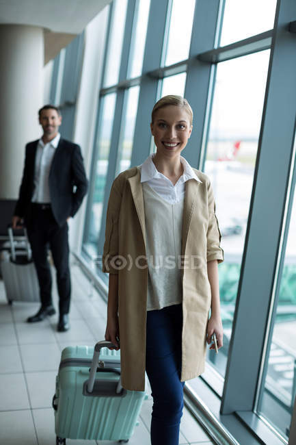 Porträt von Geschäftsleuten mit Gepäck am Flughafen — Stockfoto