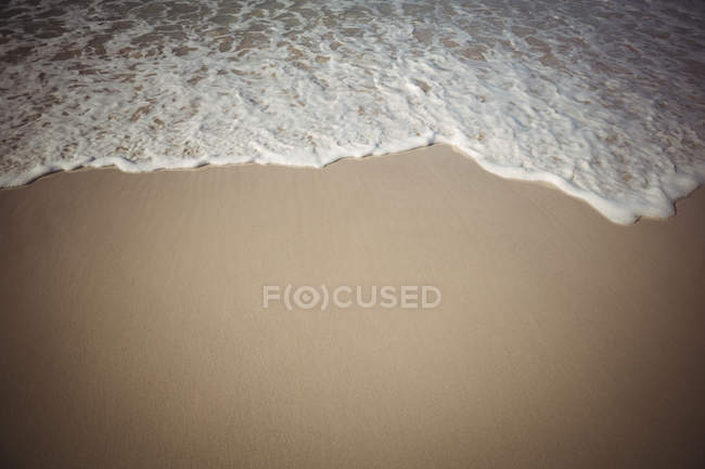 Gros plan des vagues arrivant vers la plage de sable — Photo de stock