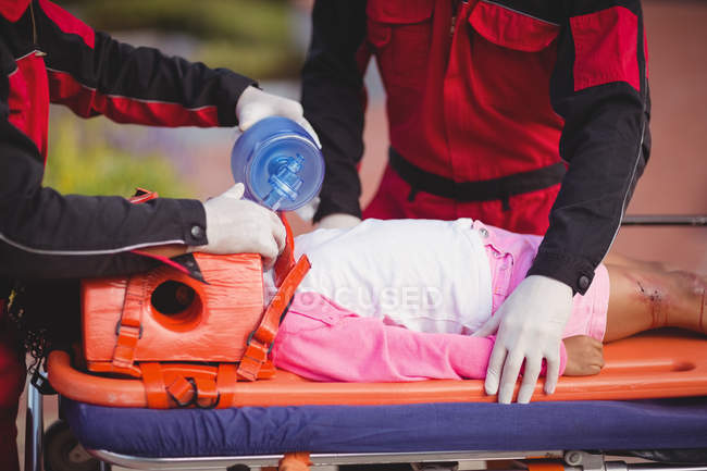 Парамедична передача кисню пораненій дівчині на місці аварії — стокове фото