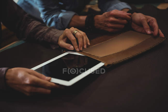 Artesanos preparando funda de cuero para tableta digital - foto de stock
