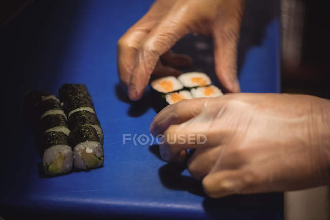 Close-up of chef hands preparing sushi in restaurant — Stock Photo