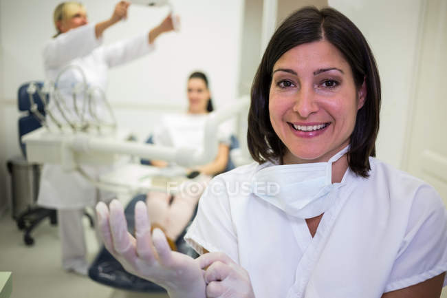 Портрет улыбающегося дантиста в хирургических перчатках — стоковое фото