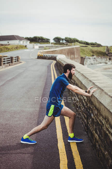 Красивий чоловік виконує розтяжку вправи в сільській місцевості — стокове фото
