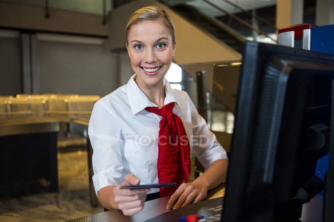 Retrato del personal femenino sonriente en la terminal del aeropuerto - foto de stock