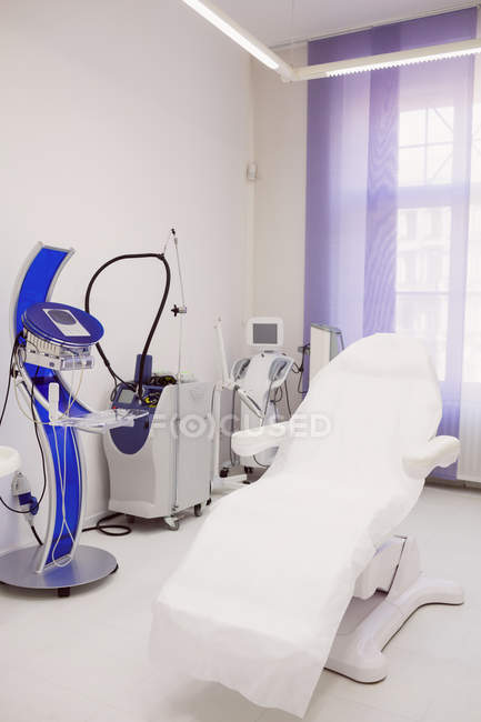 Leerer Dermatologie-Stuhl und Haarentfernungsmaschine in der Hautarztpraxis — Stockfoto