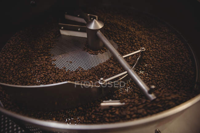 Grãos de café sendo moídos na máquina de moagem de café — Fotografia de Stock