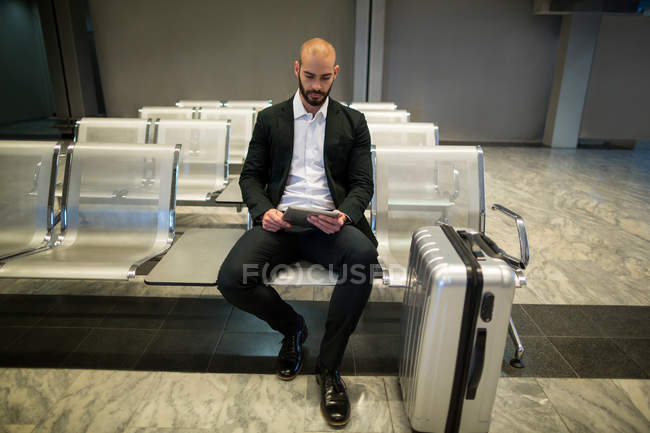 Empresario que usa tableta digital en el aeropuerto - foto de stock