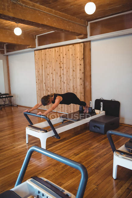 Woman Practicing Pilates On Reformer In Fitness Studio One