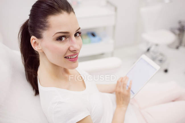 Portrait of beautiful woman using digital tablet in clinic — Stock Photo