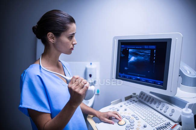 Enfermera usando dispositivo ultrasónico en el hospital - foto de stock
