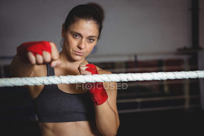 Boxer feminino confiante realizando postura de boxe no estúdio de fitness — Fotografia de Stock