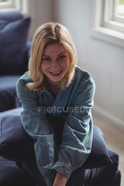 Ritratto di bella donna seduta sul divano in salotto a casa — Foto stock