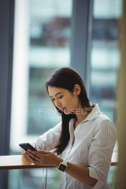 Businesswoman using mobile phone at office balcony — Stock Photo