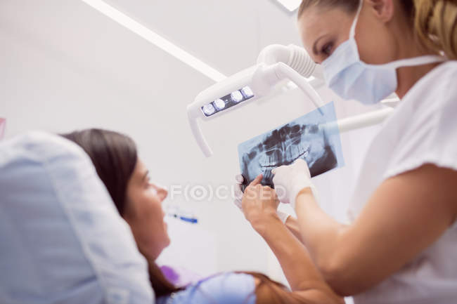 Dentista che mostra i raggi X al paziente in clinica — Foto stock