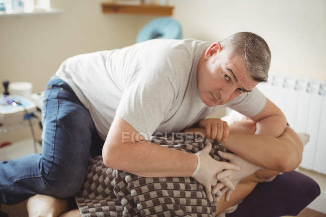 Physiothérapeute examinant le dos d'un patient à la clinique — Photo de stock
