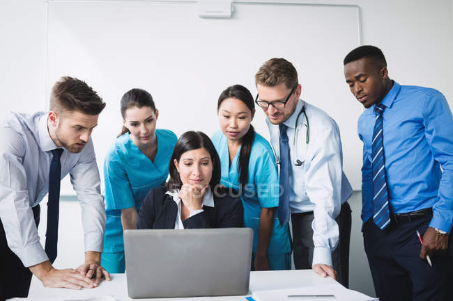 Équipe de médecin discutant sur ordinateur portable en réunion dans la salle de conférence — Photo de stock