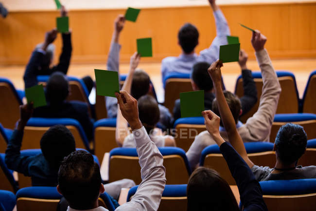 Visão traseira dos executivos de negócios mostram sua aprovação levantando as mãos no centro de conferências — Fotografia de Stock