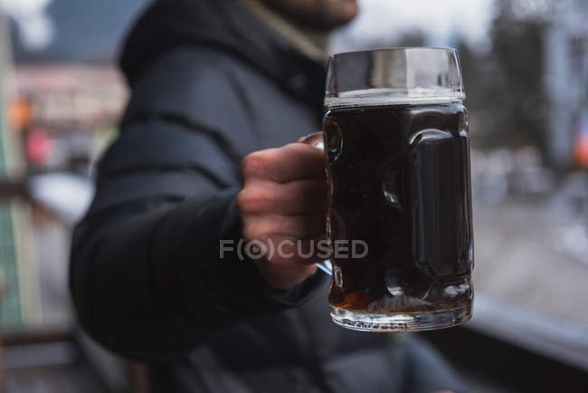 Close-up de homem segurando um copo de cerveja — Fotografia de Stock
