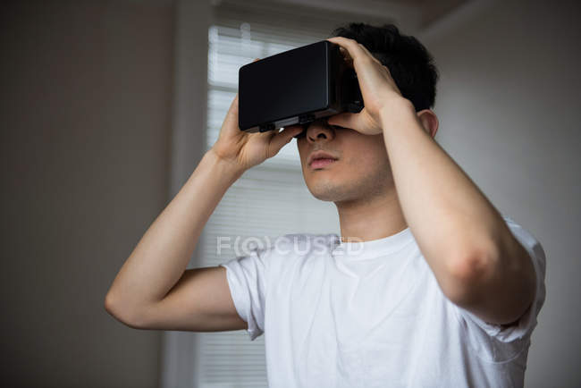 Человек с помощью гарнитуры виртуальной реальности дома — стоковое фото