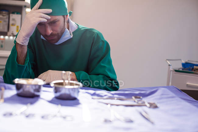 Angespannter Chirurg sitzt im Operationssaal eines Krankenhauses — Stockfoto