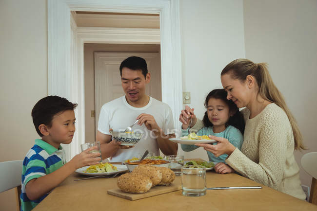 Glückliche Familie beim Essen auf dem Esstisch zu Hause — Stockfoto