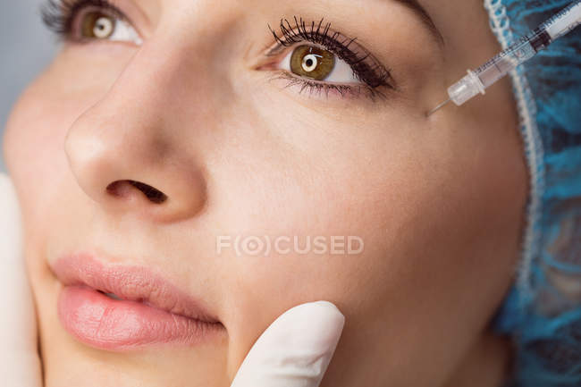 Young woman receiving botox injection on face at clinic — Stock Photo