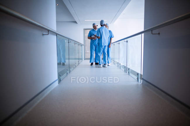 Surgeons interacting with each other in hospital corridor — Stock Photo