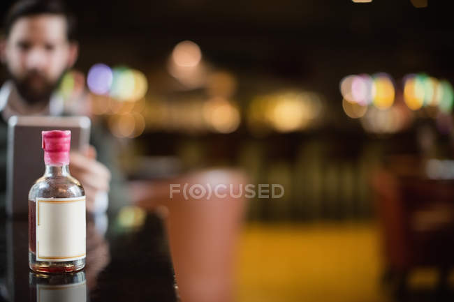 Gros plan de la petite bouteille de liqueur sur la table dans le bar — Photo de stock