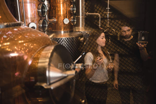 Мужчина и женщина изучают образец алкоголя на пивной фабрике — стоковое фото