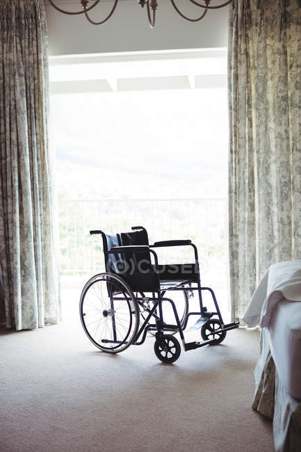 Leerer Rollstuhl im heimischen Schlafzimmer — Stockfoto