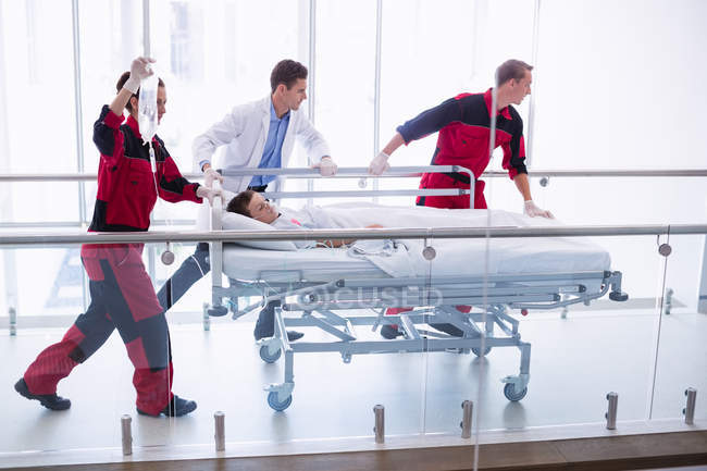 Лікарі штовхають ліжко в коридор в лікарні — стокове фото