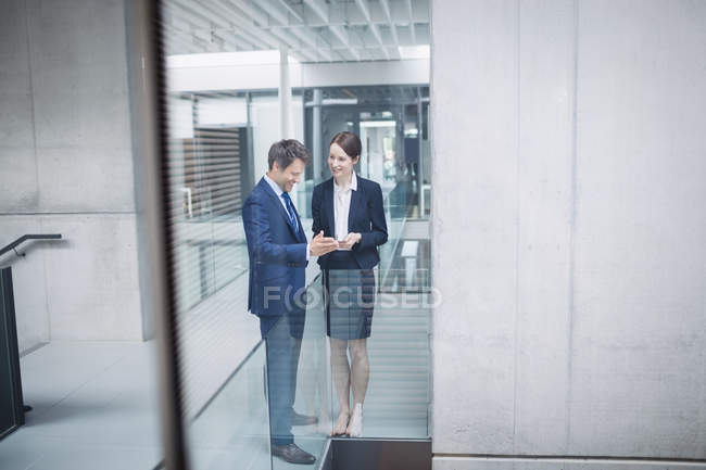 Empresário e colega discutindo sobre tablet digital dentro do prédio de escritórios — Fotografia de Stock