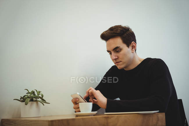 Человек, использующий мобильный телефон в кафе — стоковое фото