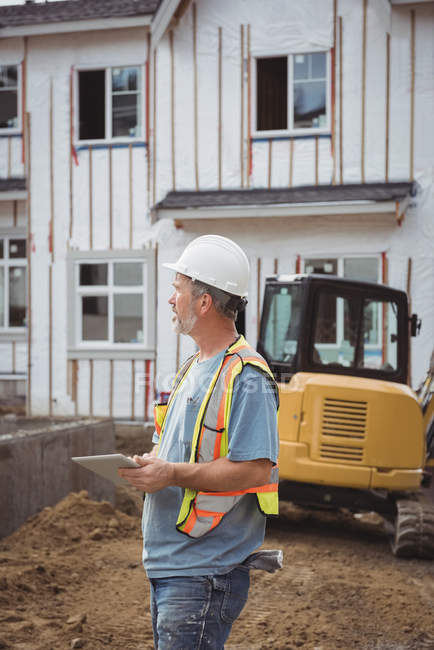 Будівельник тримає цифровий планшет на будівельному майданчику — стокове фото