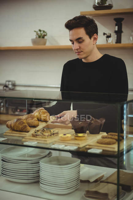 Homem removendo bandeja de croissants no café — Fotografia de Stock