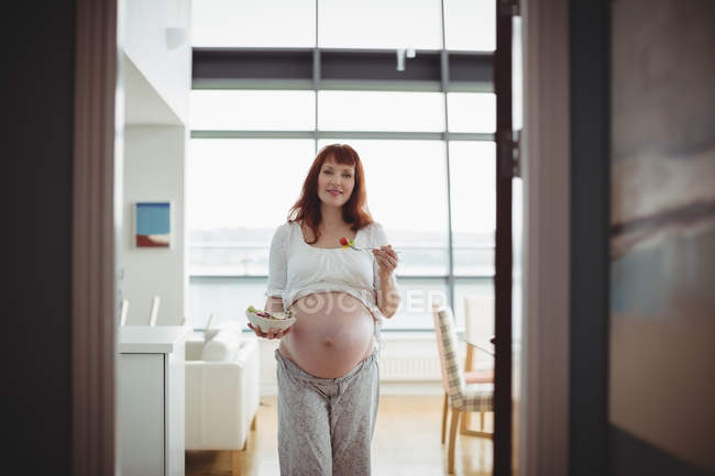 Портрет вагітної жінки, що має салат на кухні вдома — стокове фото