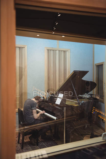 Homme jouant du piano dans un studio de musique — Photo de stock