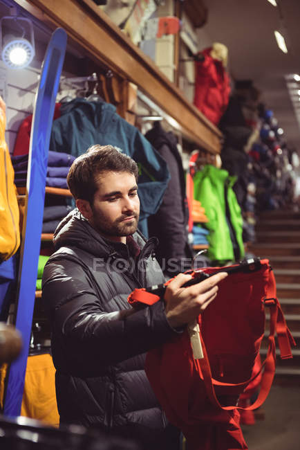 Mann sucht Kleidung in Bekleidungsgeschäft aus — Stockfoto