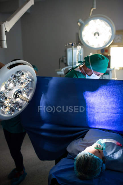 Médico examinando mulher grávida durante o parto na sala de cirurgia — Fotografia de Stock