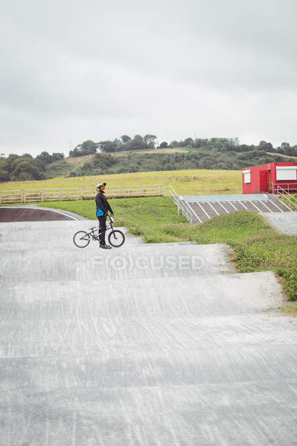 Велосипедист, стоящий на велосипеде BMX в скейтпарке — стоковое фото