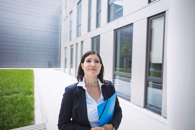 Portrait d'une femme d'affaires confiante debout devant un immeuble de bureaux — Photo de stock