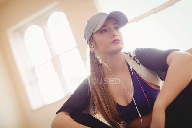 Gros plan sur une femme blonde écoutant des écouteurs dans un studio de danse — Photo de stock