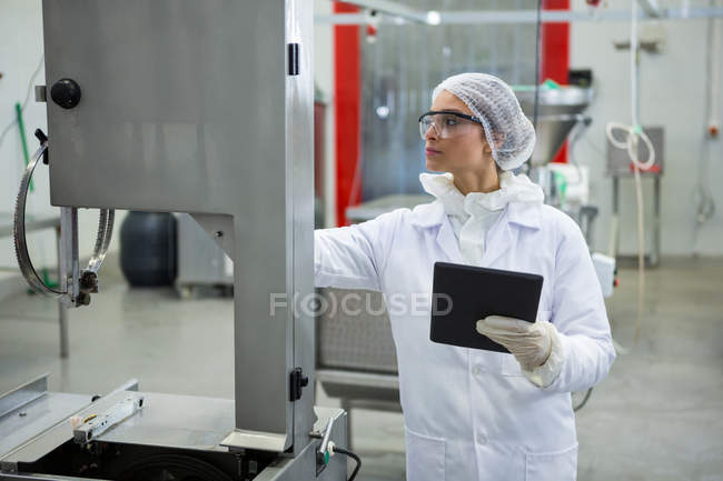 Tecnico femminile che mantiene il record su tablet digitale in fabbrica di carne — Foto stock