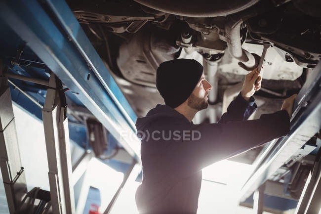 Mecânico de fixação de um carro na garagem de reparação — Fotografia de Stock