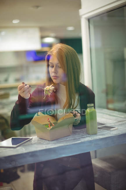 Redhead woman eating salad in the restaurant — Stock Photo