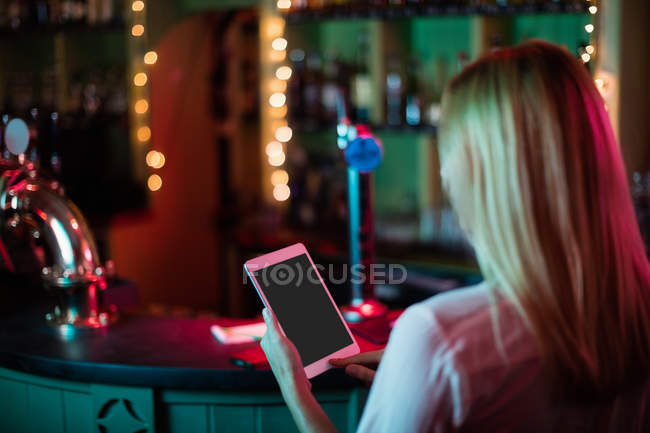 Visão traseira da garçonete usando um tablet digital no bar — Fotografia de Stock