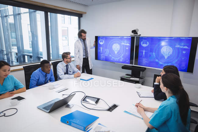 Médico dando apresentação à equipe de médicos interinos na sala de conferências — Fotografia de Stock